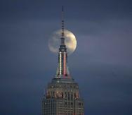 La Luna llena se alza por detrás del Empire State Building vista desde Jersey City, Nueva Jersey. (AP)