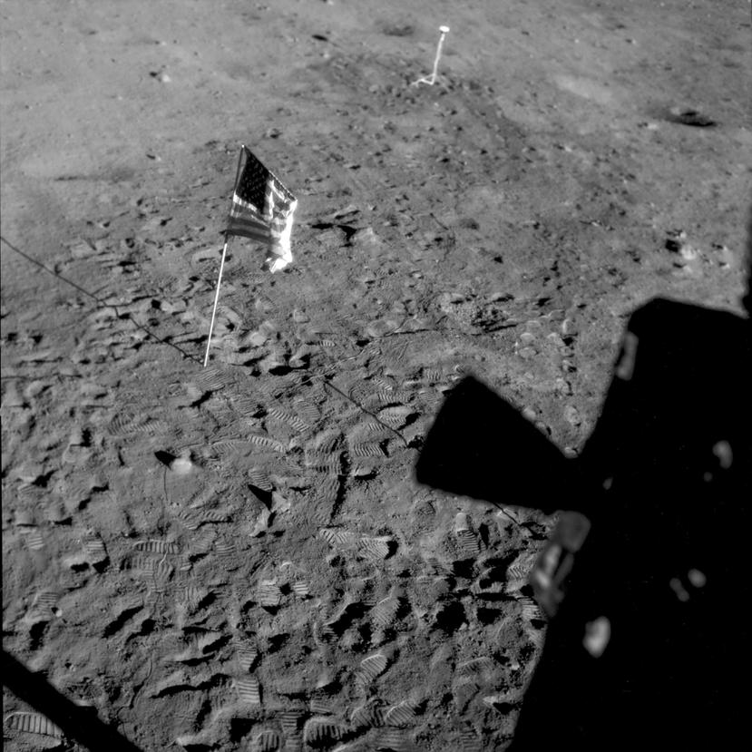 Esta foto del 21 de julio de 1969, facilitada por la NASA, muestra una bandera estadounidense plantada en la Base Tranquilidad, en la superficie de la Luna, y la silueta de un propulsor a la derecha, vista desde una ventana del Módulo Lunar.
