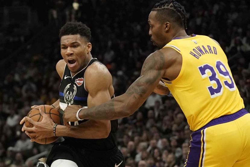 Giannis Antetokounmpo, de los Bucks de Milwaukee, ataca hacia el canasto tratando de evadir la defensa del corpulento Dwight Howard, de los Lakers. (AP / Morry Gash)