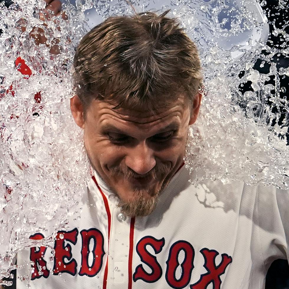 Tanner Houck, de los Red Sox de Boston, es empapado con la hielera en el festejo tras su juego completo.