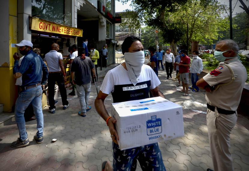 Gente haciendo fila para comprar alcohol, ante una de las licorerías que reabrieron el lunes tras seis semanas de confinamiento en Nueva Delhi, India. (AP)