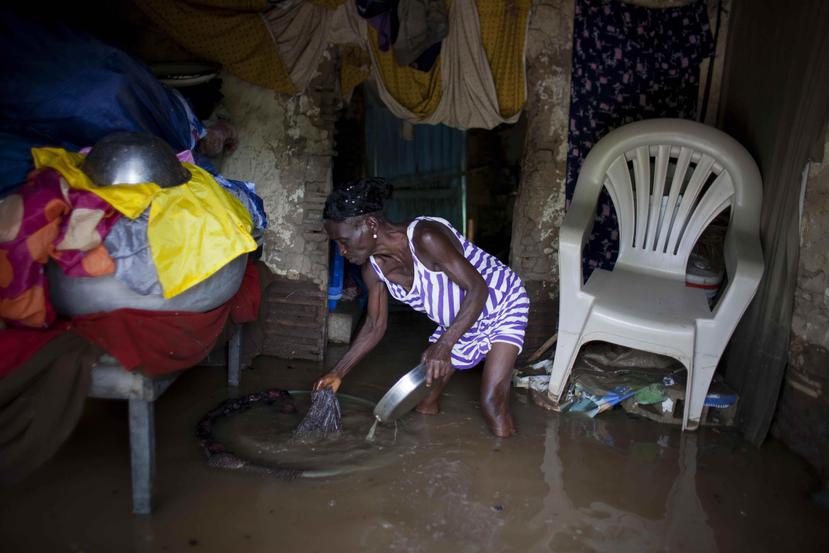 Lucita Leonce, de 71 años, rescata artículos de su casa, inundada por las fuertes lluvias provocadas por el huracán Irma, en Fort-Liberte, Haití. (AP)