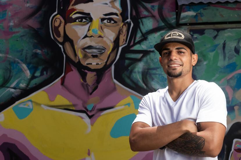 Purin Caraballo posa frente a un mural con la imagen suya en el negocio “Tolón Tolón”, ubicado en el barrio Sitios del sector Playita.
