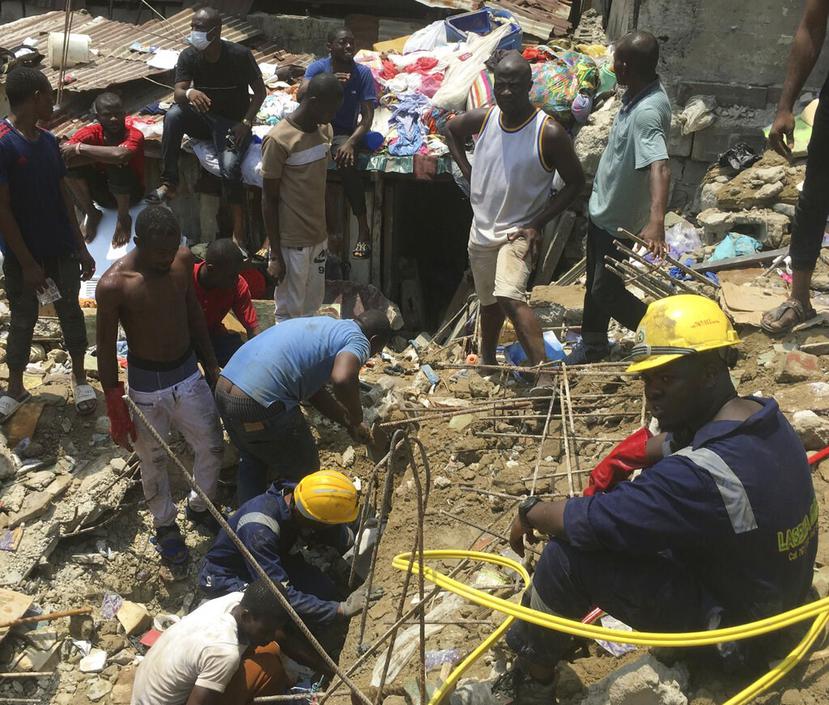 Socorristas y residentes locales excavan en el sitio del derrumbe de una escuela en un barrio densamente poblado en Lagos, Nigeria. (AP)