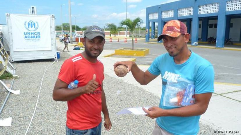 Carlos Alberto Jiménez (izquierda) y otro refugiado de su grupo muestran a su coco "Wilson". (DW / O. Pieper)