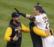 Kevin Newman es abrazado por un compañero de equipo luego de pegar el imparable impulsador que le dio la victoria a los Pirates.