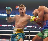 En esta fotografía del 8 de mayo de 2021, el mexicano Saúl "Canelo" Álvarez (izquierda) le pega a Billy Joe Saunders durante una pelea de box en Arlington, Texas.