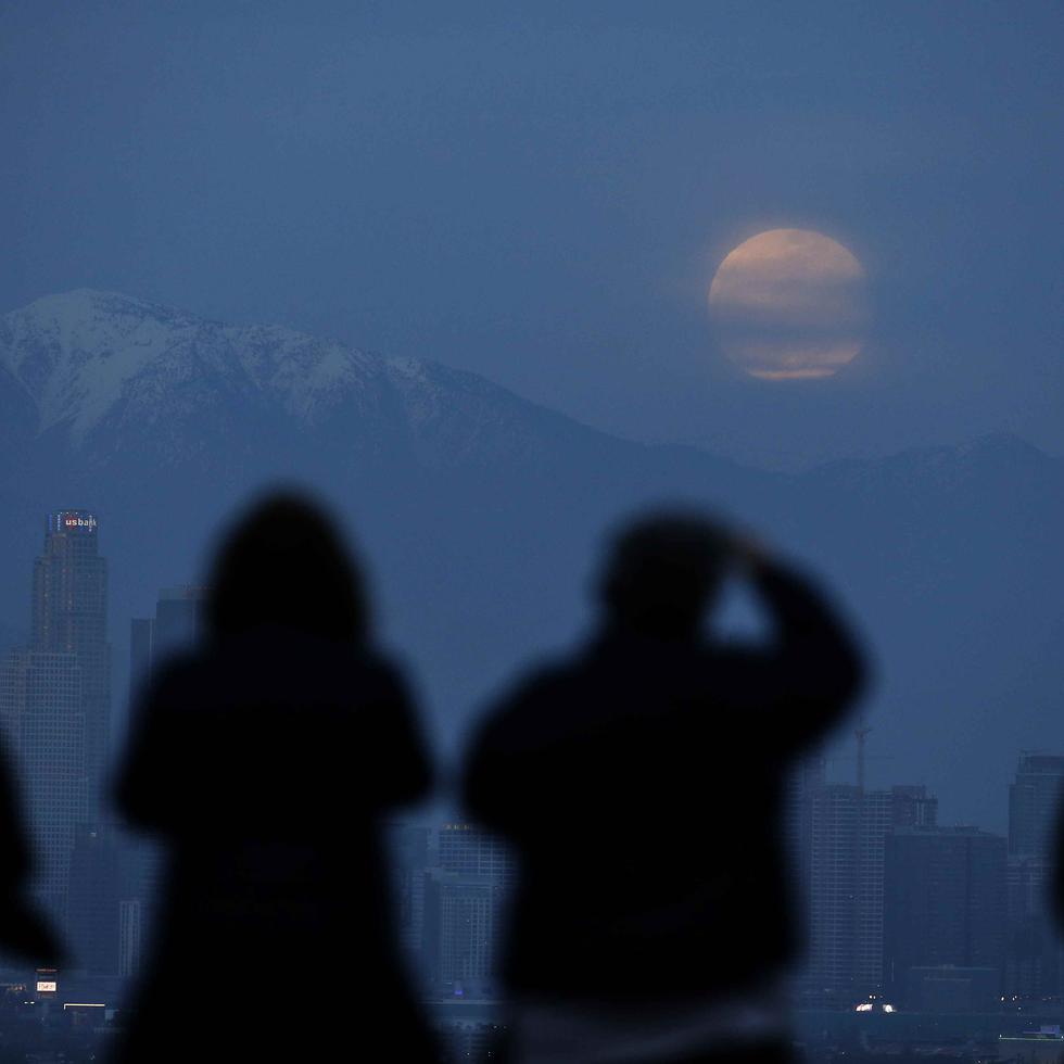 Un grupo de personas observa la superluna por detrás del skyline de Los Ángeles, desde el Parque Kenneth Hahn de la ciudad, el 20 de enero de 2019. (AP)