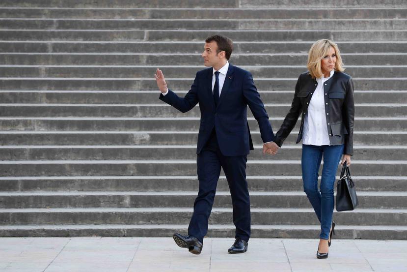 El presidente francés Emmanuel Macron llega con su esposa Briggite a una entrevista con el canal televisivo BFM y el diario digital de investigación Mediapart, en el Teatro Nacional de Chaillot en París. (AP)