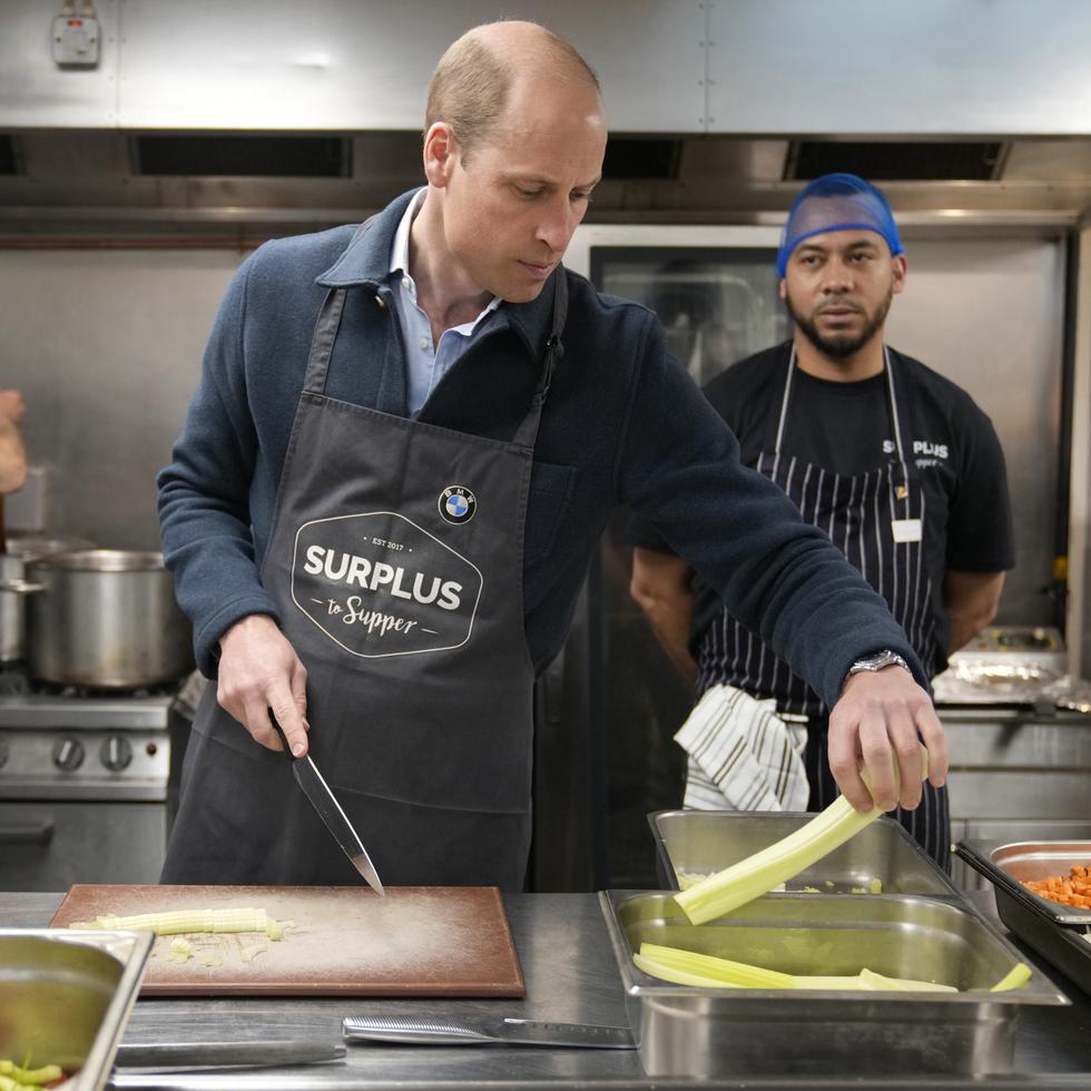 El príncipe William ayuda en la cocina durante su visita al proyecto Surplus to Supper, en Surrey, Inglaterra.