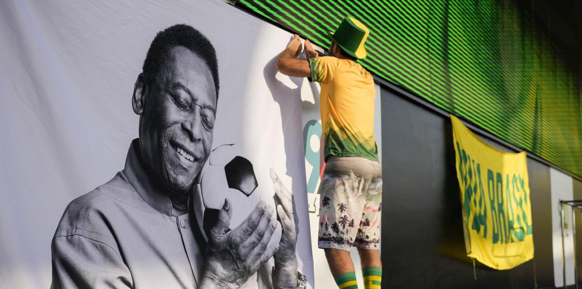 Un aficionado coloca un cartel de apoyo a Pelé en una fiesta de torcedores de Brasil previo al partido contra Corea del Sur.