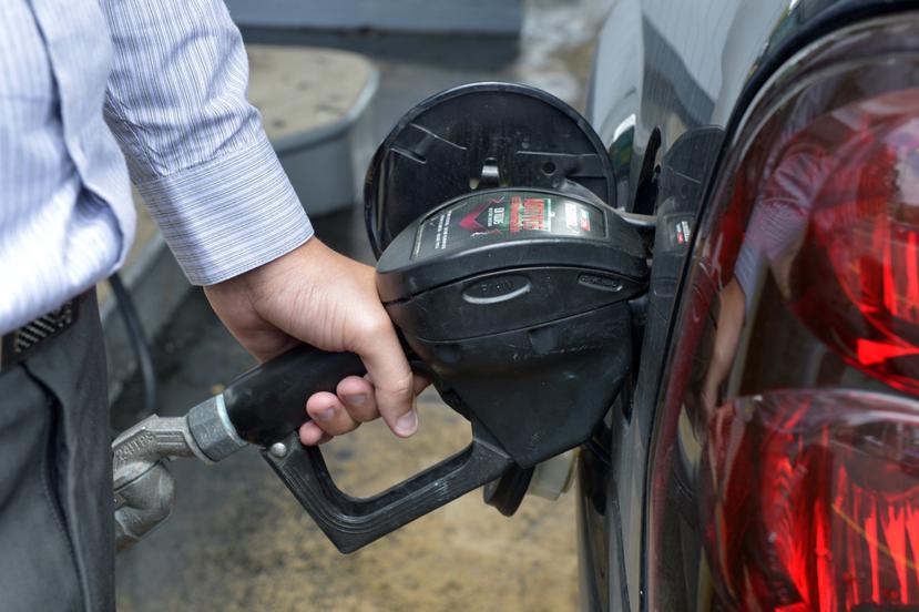 Imagen de archivo de una persona mientras echa gasolina a su vehículo.