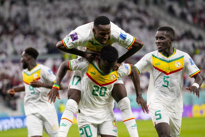Compañeros senegaleses celebran con Bamba Dieng luego de que este anotó el tercer gol del encuentro para vencer 3-1 a Catar.