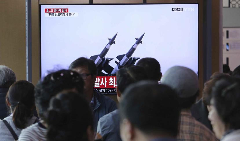 Un grupo de personas observa un televisor en el que se emiten imágenes de archivo de misiles norcoreanos. (AP)