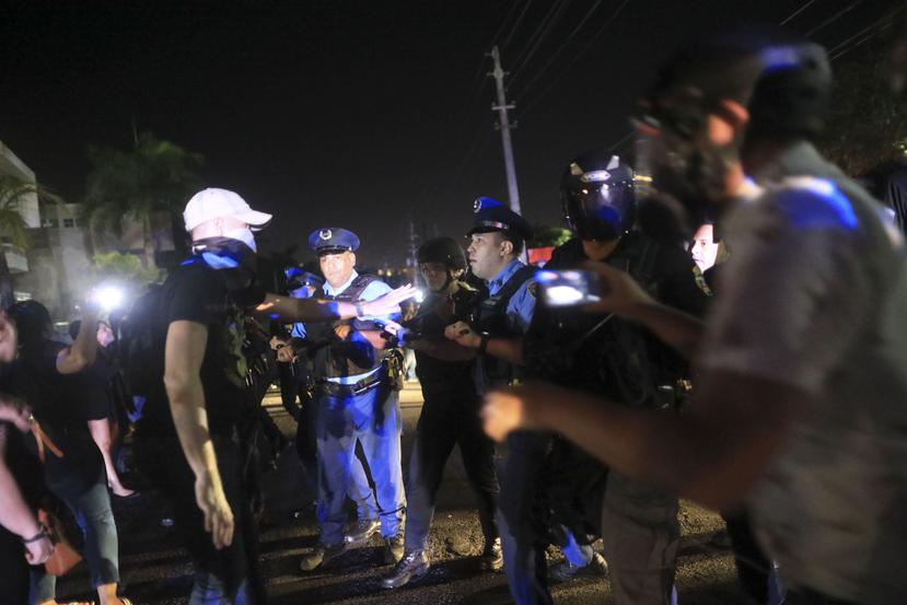 Varios manifestantes hablan con los oficiales de la Policía que llegaron a la protesta en Guaynabo.