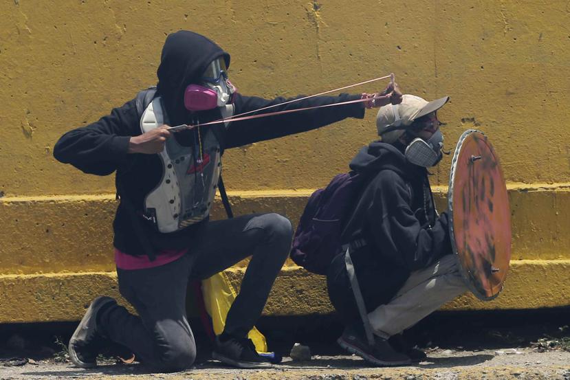 Manifestantes acudieron con armaduras improvisadas durante las protestas de hoy. (AP / Fernando Llano)