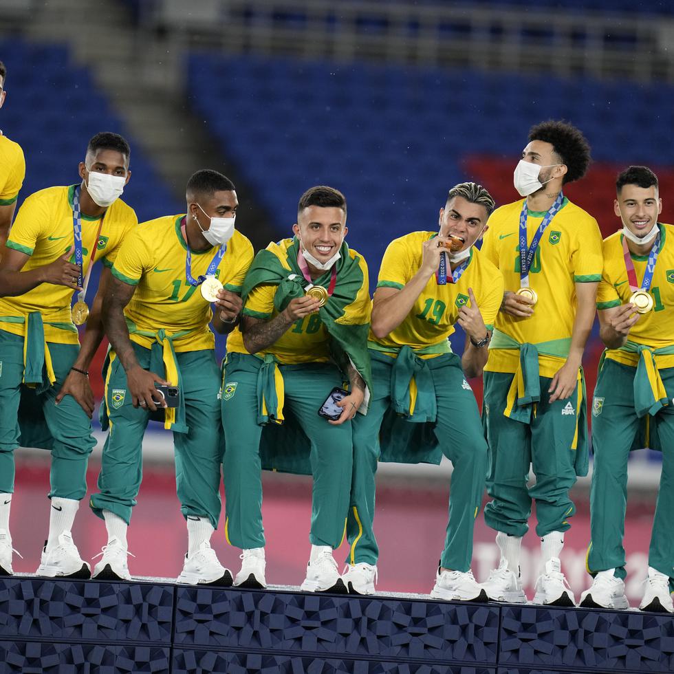 Integrantes del equipo de fútbol de Brasil celebran con la medalla de oro.