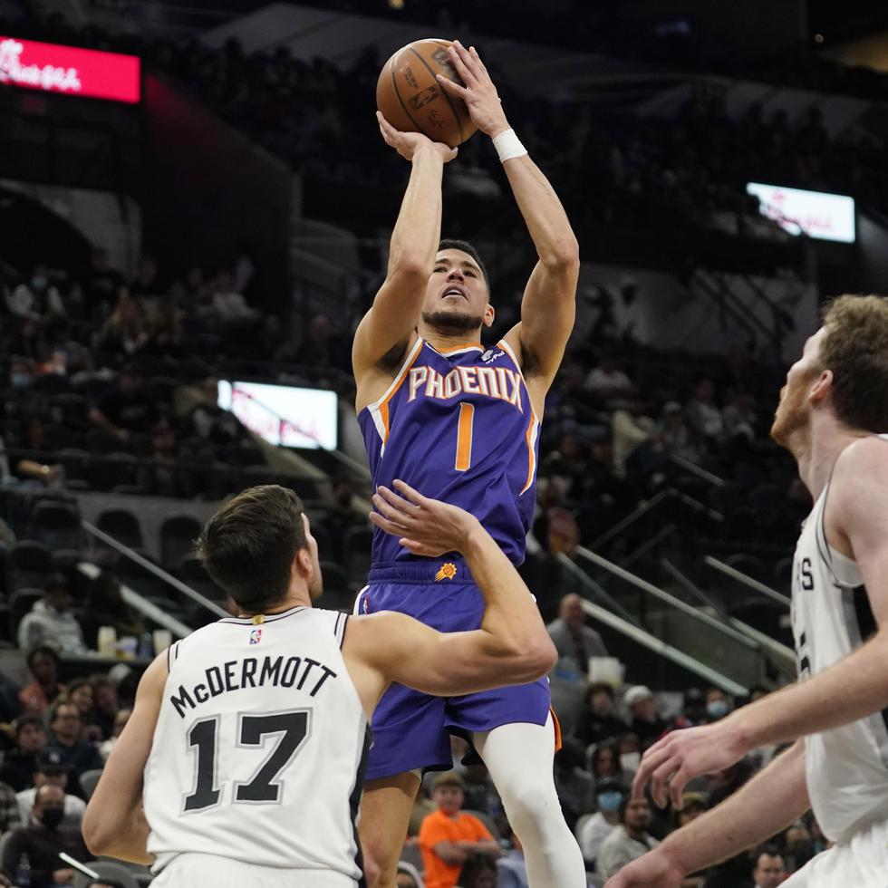 El escolta de los Suns de Phoenix Devin Booker dispara en la segunda mitad del partido ante los Spurs de San Antonio.
