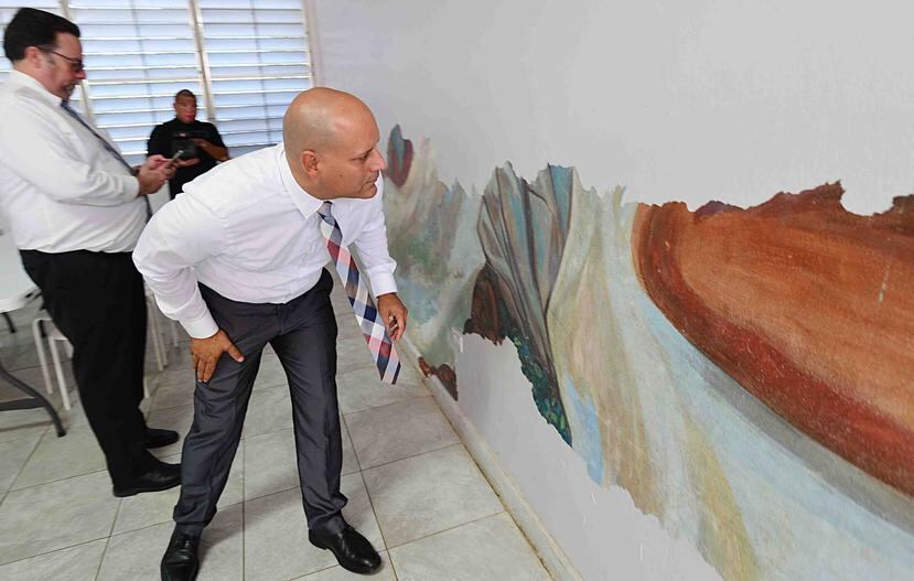 Guillermo Miranda inspecciona el mural.