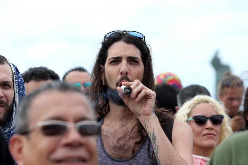 Un hombre fuma frente al Capitolio durante la manifestación.