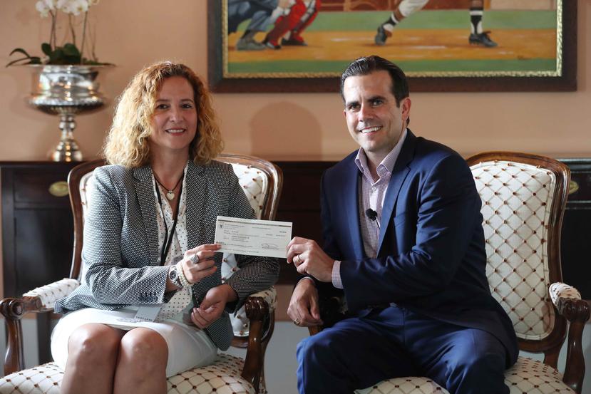El gobernador Ricardo Rosselló y la presidenta del Copur, Sara Rosario, posan junto al cheque.