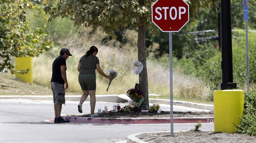Flores, velas y animales de peluche descansan en un homenaje improvisado en el estacionamiento de una tienda Walmart cerca del lugar donde las autoridades descubrieron el 23 de julio un camión cargado de inmigrantes. (AP)