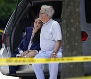 Un hombre consuela a una joven con una toga tras ocurrir un tiroteo en una ceremonia de graduación en Louisiana.