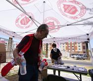 Un voluntario del Ejército de Salvación, distribuye botellas de agua en una estación de asistencia debido al calor que alcanzó 114 grados Fahrenheit, en Phoenix.