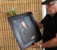 Isaías Roldán mira la foto de su hija desaparecida, Rebecca Joanne Roldán Nieves.