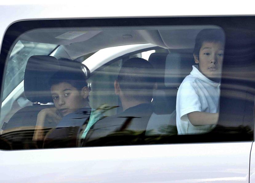 Niños se asoman por la ventana de una camioneta al llegar a Servicios Sociales Luteranos. (AP)