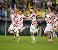 Jugadores de Croacia corren a toda prisa para celebrar el triunfo 4-2 en penales sobre Brasil.