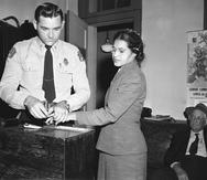 Un agente le toma las huellas digitales a Rosa Parks, tras ser detenida por violar una ordenanza que obligaba a los pasajeros de raza negra a sentarse en el fondo de los autobuses. (AP)