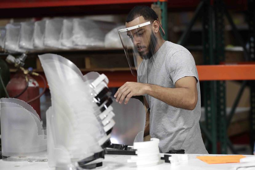 Jonathon Pedrosa, un empleado de Faulkner Plastics, ensambla escudos faciales de plástico en la fábrica de la empresa en Hialeah, Florida. (AP Photo/Lynne Sladky)