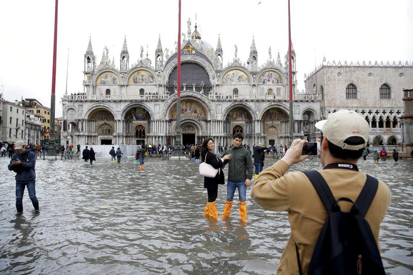 Turistas se toman fotos en la inundada Plaza de San Marcos, Venecia. (AP)