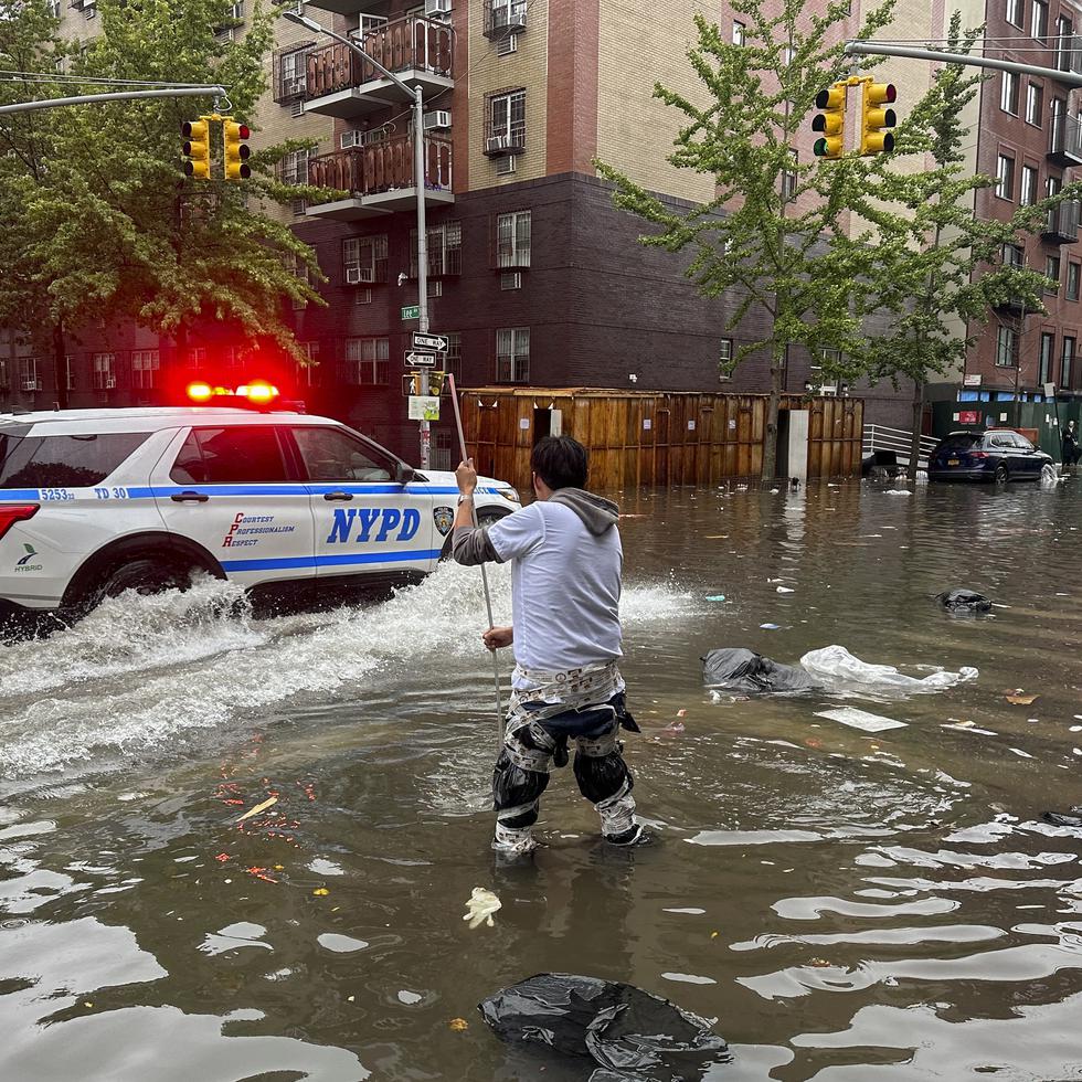 Un hombre trabaja para limpiar un desagüe en las aguas de una inundación, el viernes 29 de septiembre de 2023, en el distrito de Brooklyn de Nueva York.