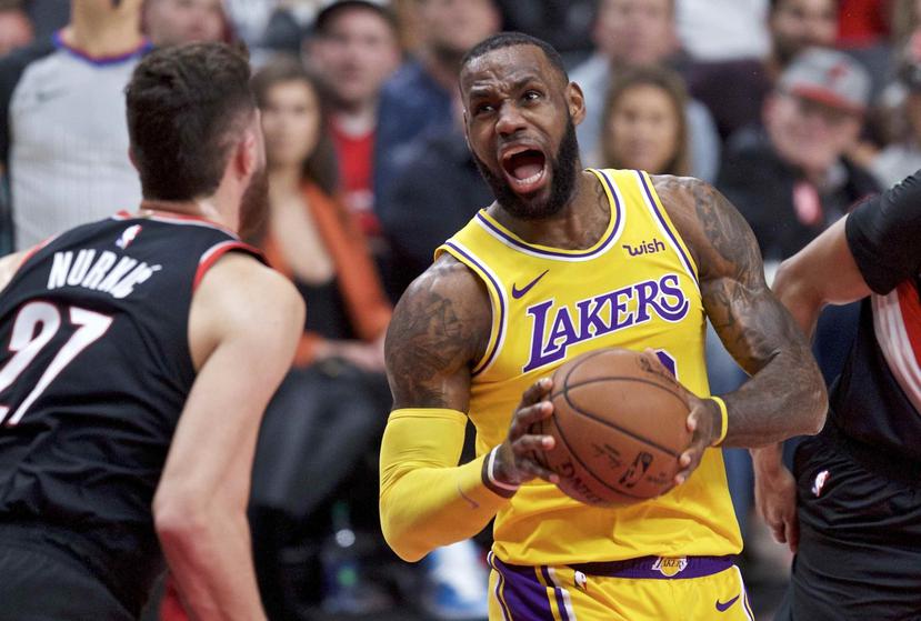 El alero LeBron James, derecha, de los Lakers de Los Ángeles avanza hacia la canasta mientras el pívot bosnio Jusuf Nurkic de los Trail Blazers de Portland intenta detenerlo, en Portland, Oregon, el sábado 3 de noviembre de 2018. (AP)