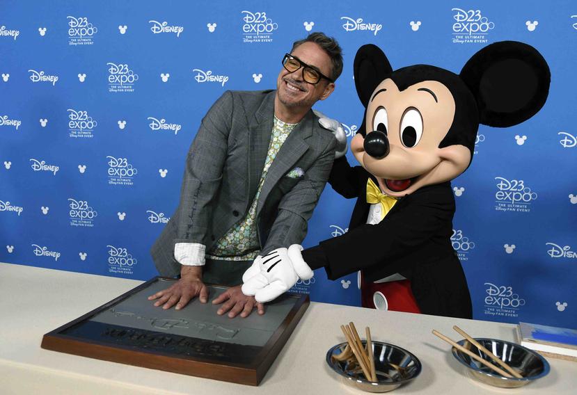 El actor Robert Downey Jr. posó junto a Mickey Mouse luego de estampar sus manos durante una ceremonia para conmemorar las leyendas de Disney, en el expo D23. (AP)