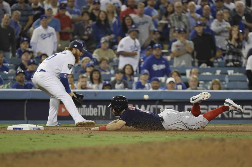 Ian Kinsler, de los Medias Rojas de Boston, se desliza con seguridad hacia el tercera cuando Justin Turner de los Dodgers de Los Ángeles espera el lanzamiento durante la décima entrada en el Juego 3 del juego de béisbol de la Serie Mundial el viernes 26 d