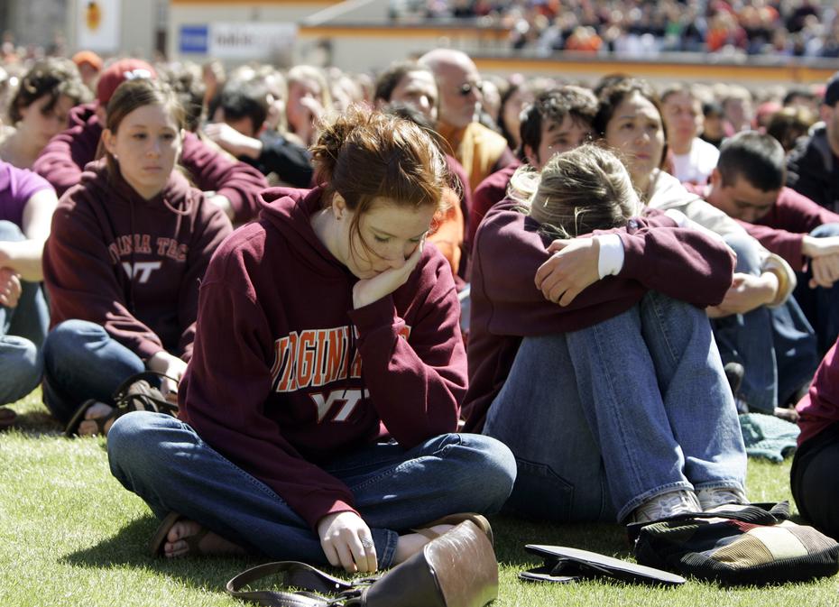Estudiantes inclinan sus cabezas durante un momento de silencio por las víctimas, en el estadio de fútbol del campus de Virginia Tech, el 17 de abril de 2007.
