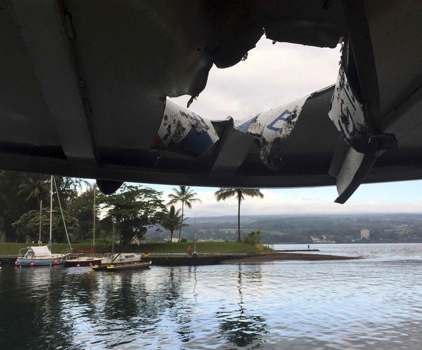 Esta fotografía proporcionada por el Departamento de Tierras y Recursos Naturales de Hawaii muestra el daño sufrido por el techo de un bote para turistas después de que le cayó lava del volcán Kilauea frente a la Isla Grande del archipiélago, el lunes 16