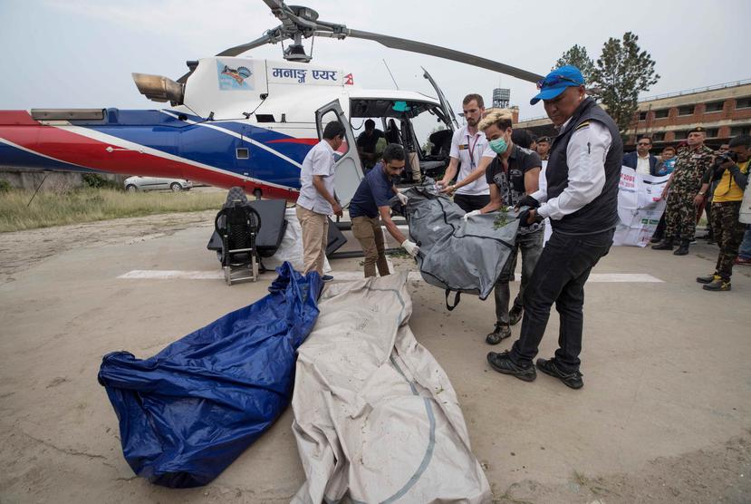 Policías nepalíes y miembros de los servicios de rescate transportan los cuerpo de los escaladores fallecidos en el monte Everest, Nepal. (EFE)