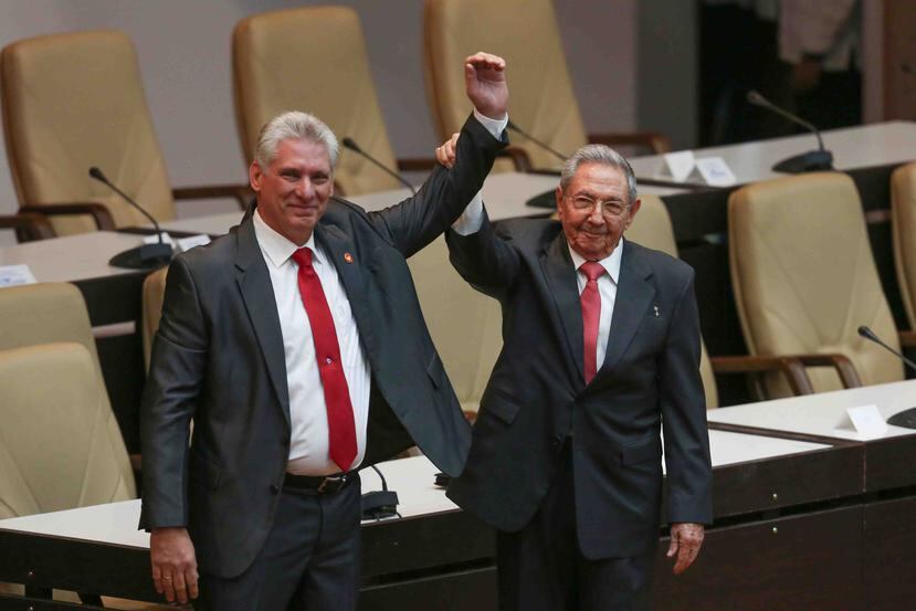 El primer secretario del Partido Comunista de Cuba y ya expresidente Raúl Castro (d) levanta el brazo del nuevo presidente nuevo presidente, Miguel Díaz-Canel. (EFE)
