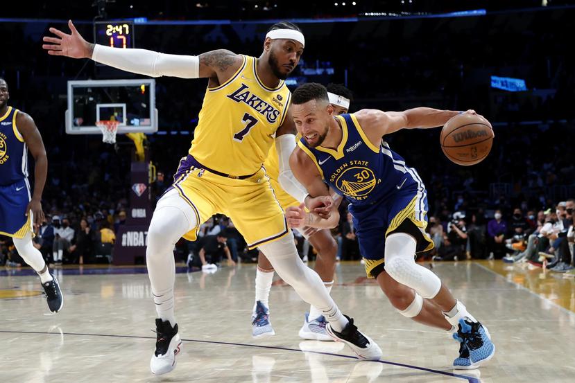 Stephen Curry, de los Warriors, maneja el balón contra Carmelo Anthony, nuevo integrante de los Lakers.