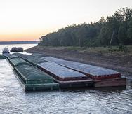 Barcazas paradas aguardan pasar por el río Mississippi.
