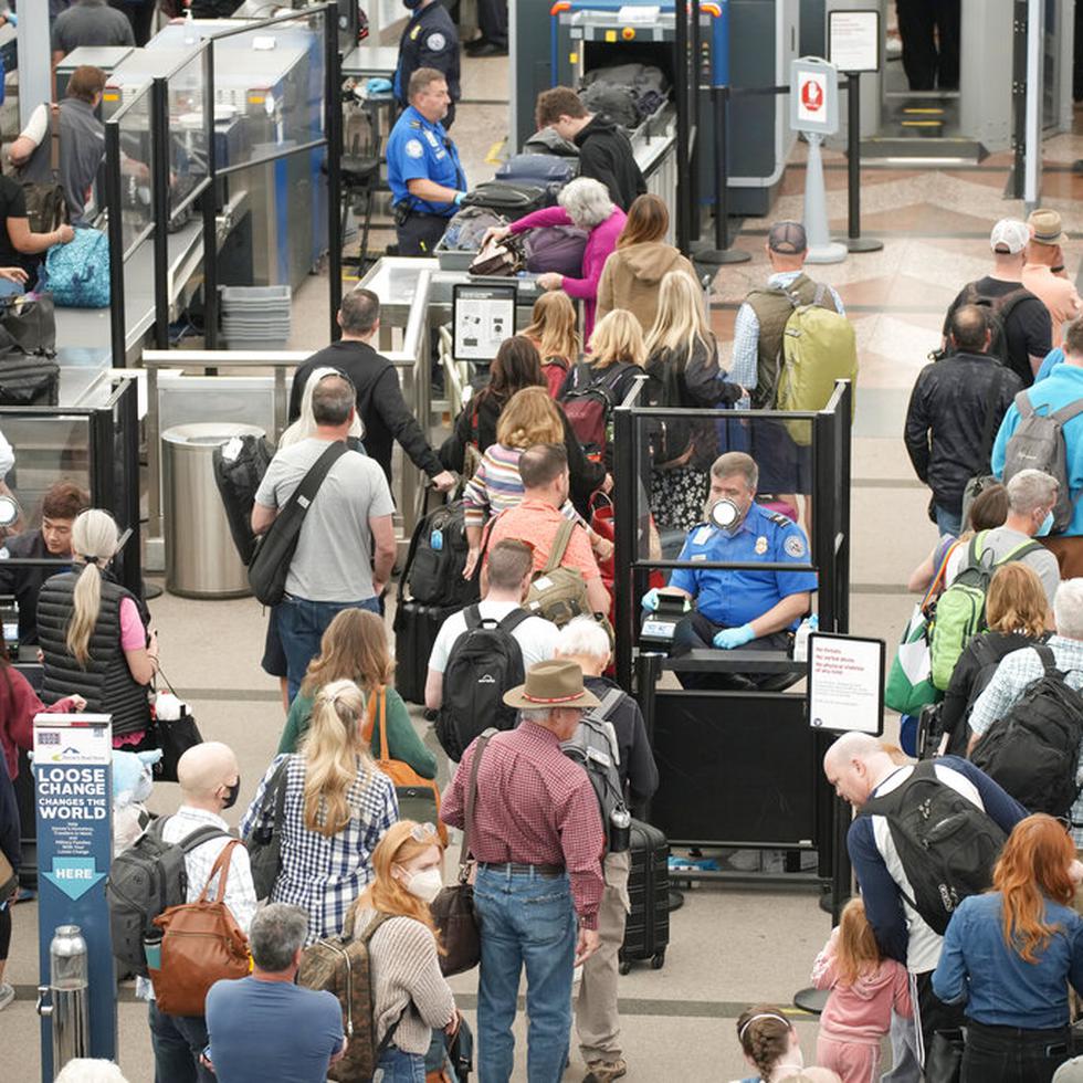 Numerosos viajeros hacen fila en un punto de revisión en el principal terminal del Aeropuerto Internacional de Denver, en Colorado, el 26 de mayo de 2022.