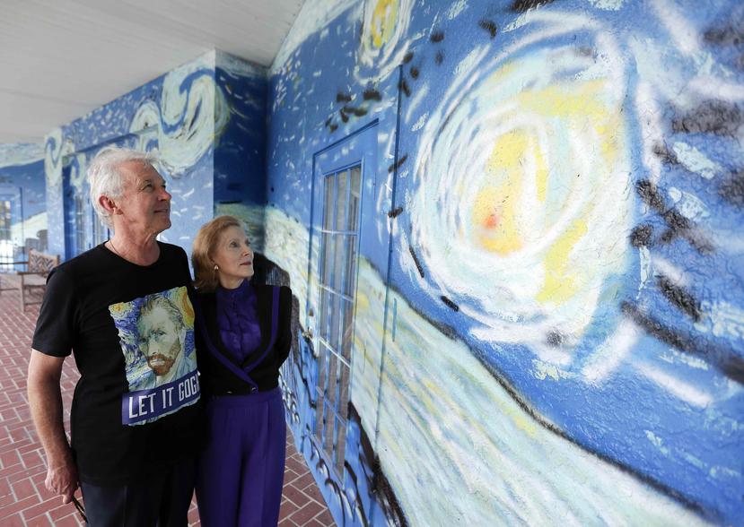 Lubomir Jastrzebski y Nancy Nemhauser parados junto a un pedazo del mural en su hogar. (AP)