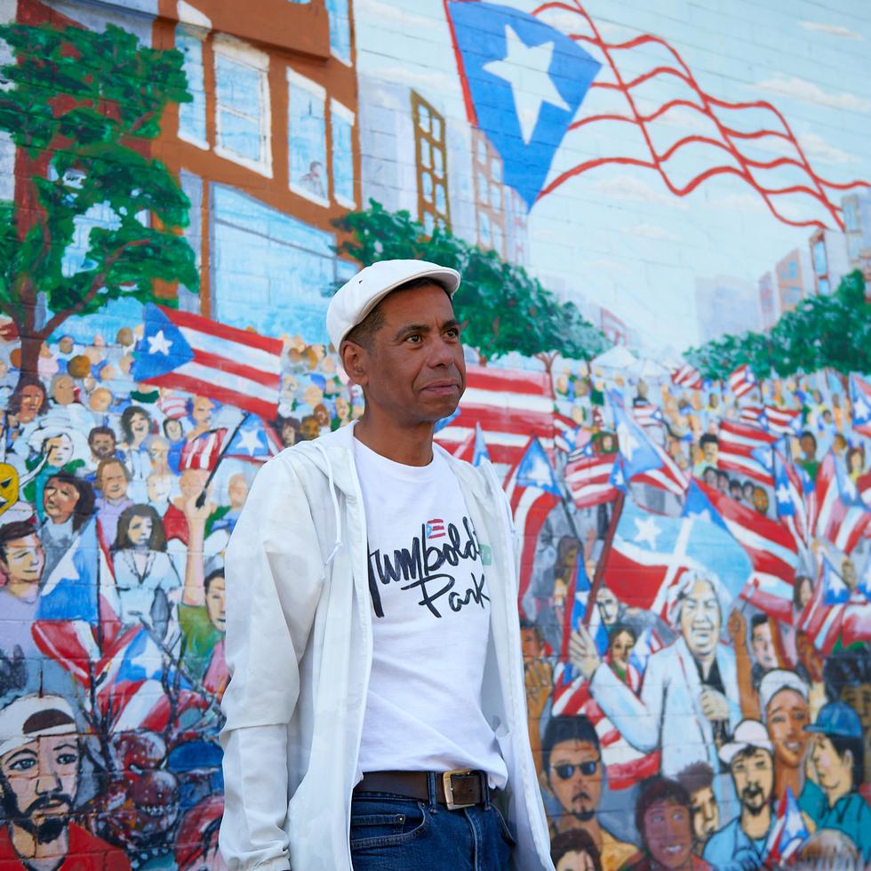 El Paseo Boricua destaca por su arte público, y específicamente sus murales. Hay sobre 80 murales en este pequeño microcosmos de Puerto Rico en la diáspora, como este: “Mar de Banderas” (2005), de Gamaliel Ramírez. En la foto, Eduardo Arocho, quien ofreció un tour de la zona.