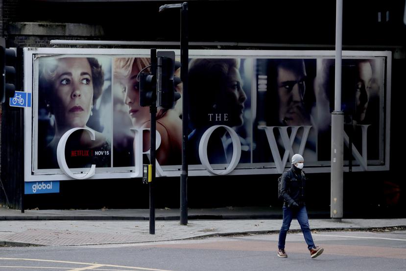 Un hombre pasa frente a un anuncio de la serie de Netflix "The Crown" en Londres.