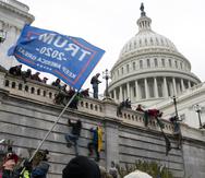 Esta foto del 6 de enero del 2021 muestra a violentos partidarios del presidente Donald Trump escalando el muro del Capitolio en Washington.