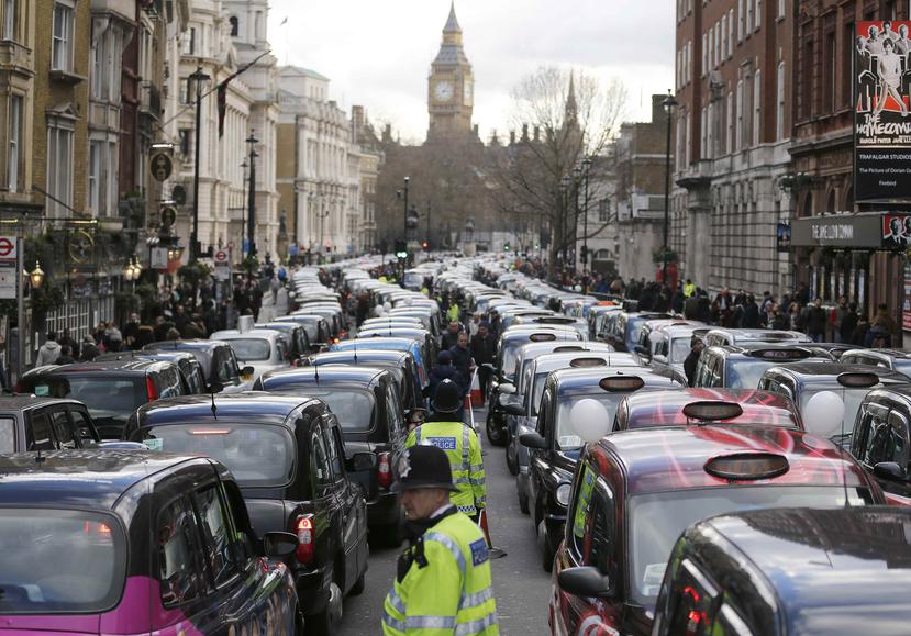En esta imagen del 2016, taxistas londinenses bloquean una calle durante una protesta en el centro de Londres en la que denunciaban competencia desleal de servicios como Uber. (AP)